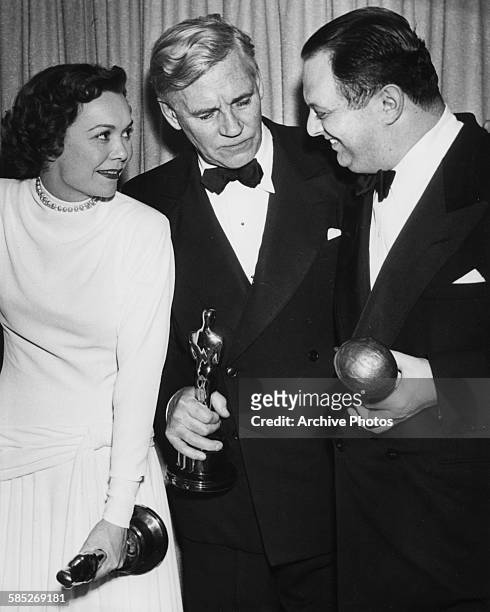 Actors Jane Wyman and Walter Huston holding their acting Oscars, with producer Jerry Wald holding his Irving G Thalberg Memorial award, at the 21st...