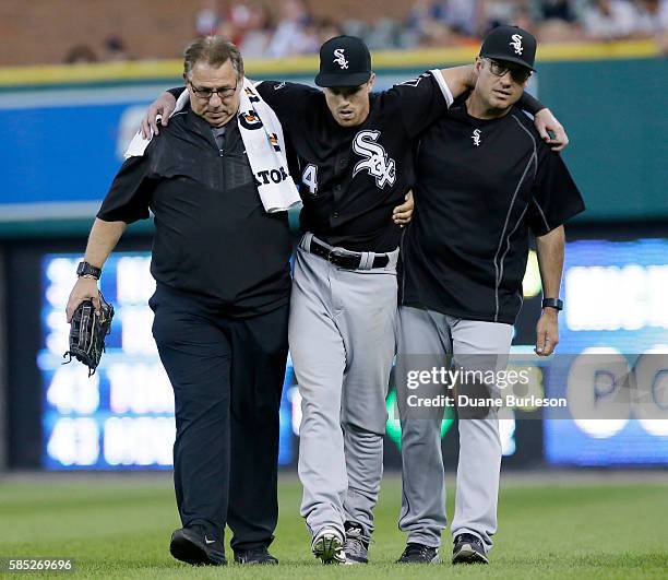 Charlie Tilson of the Chicago White Sox is helped off the field by trainer Herm Schneider, left, and manager Robin Ventura of the Chicago White Sox...