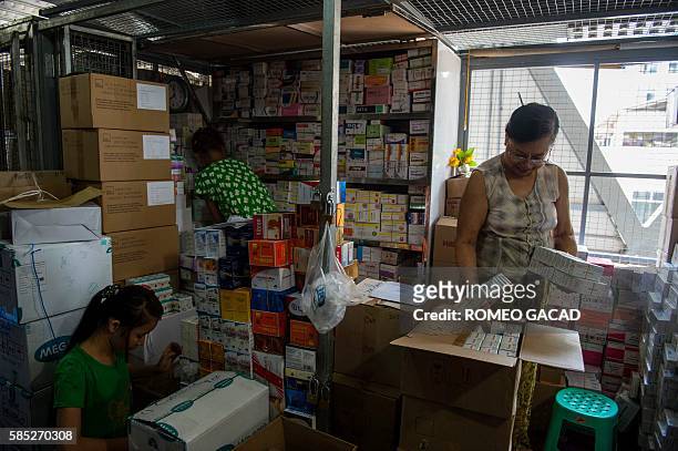 In this photo taken on May 12 Myanmar pharmacy shop owner Aye Aye Nge inspects items from her stall in a new commercial building at the Shwe Mingalar...
