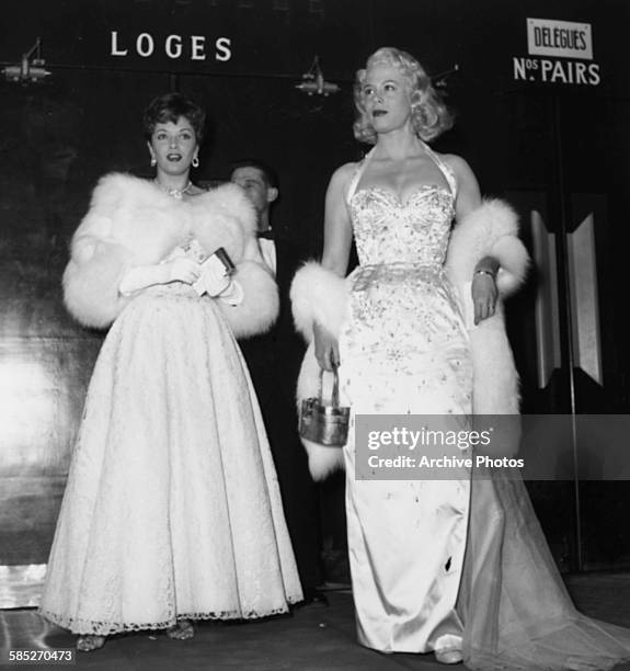 Actress Diana Dors wearing a long gown and fur stole as she attends the Cannes Film Festival, March 26th 1954.