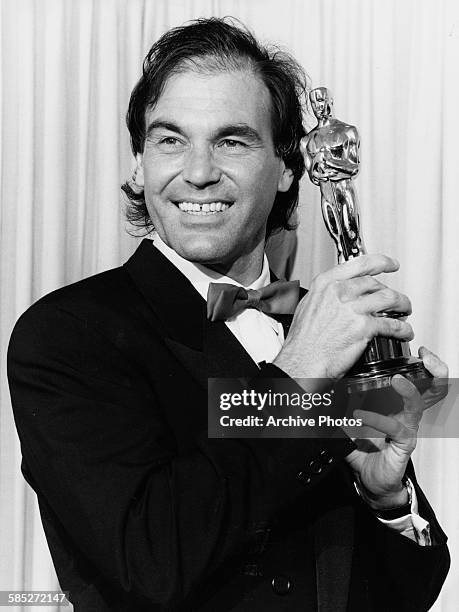 Director Oliver Stone holding his Oscar statuette at the 62nd Academy Awards, Los Angeles, March 26th 1990.