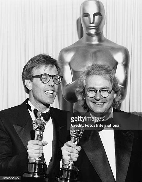 Director Barry Levinson and producer Mark Johnson holding their Oscar statuettes for the film 'Rain Man', at the 61st Academy Awards, at the Shrine...