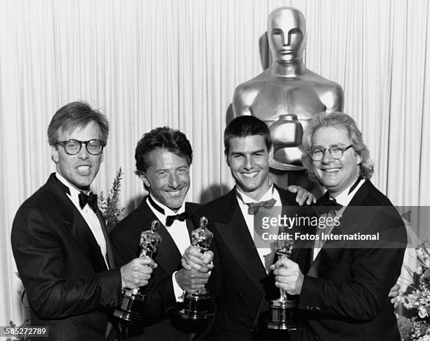Director Barry Levinson , producer Mark Johnson and actor Dustin Hoffman holding their Oscar statuettes for the film 'Rain Man', with co-star Tom...