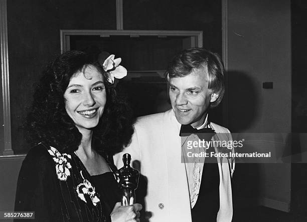 Actress Mary Steenburgen holding her Best Supporting Actress Oscar for the film 'Melvin and Howard', with her husband Malcolm McDowell, at the 53rd...