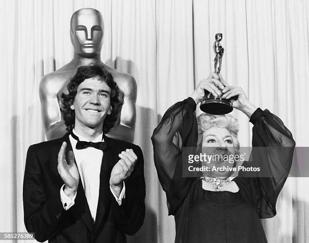 Actress Maureen Stapleton holding her Oscar for best supporting actress above her head, which she won for the film 'Reds', with former Oscar winner...
