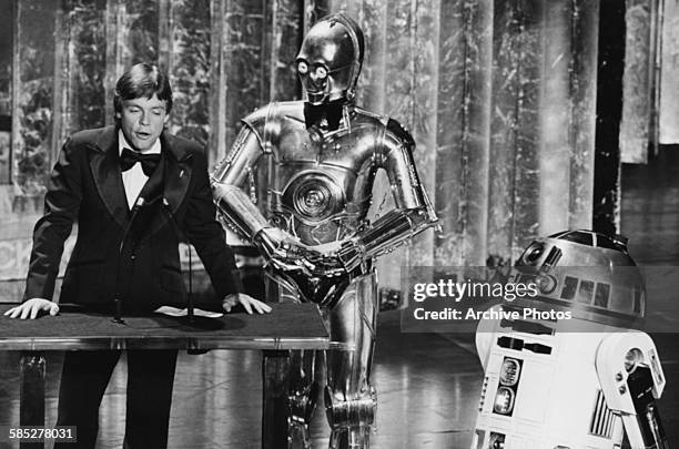 Actor Mark Hamill presenting an award with his Star Wars co-stars C3PO and R2D2, at the 50th Academy Awards, Los Angeles, April 3rd 1978.