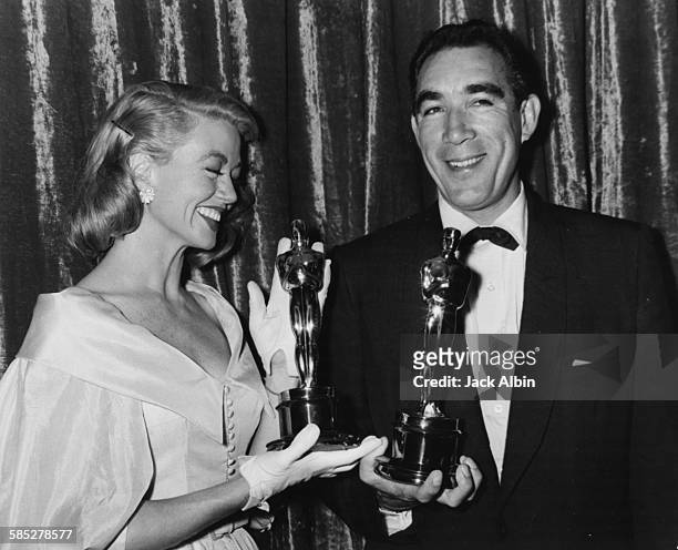 Actors Dorothy Malone and Anthony Quinn holding their Oscars at the 29th Academy Awards, March 27th 1957.