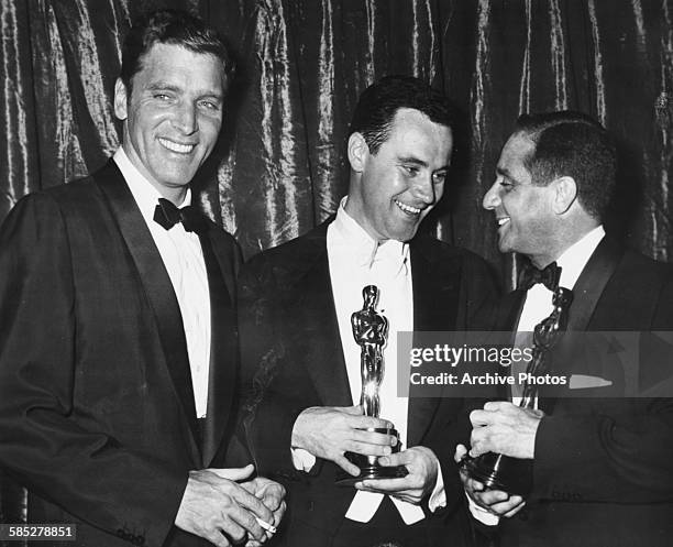 Director Harold Hecht holding his Oscar for the film 'Marty', and actor Jack Lemmon holding his Oscar for 'Minister Roberts', being congratulated by...