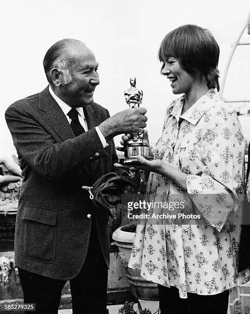 Actress Glenda Jackson receiving her Best Actress Oscar from producer Hal B Willis, for the film 'Women in Love', after she missed the ceremony, at...
