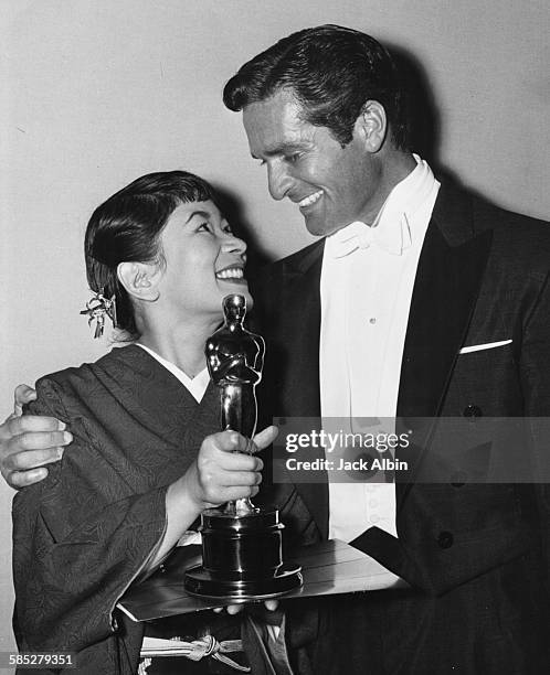 Actress Miyoshi Umeki holding her Best Supporting Actress Oscar for the film 'Sayonara', with presenter Hugh O'Brien, at the 30th Academy Awards, Los...