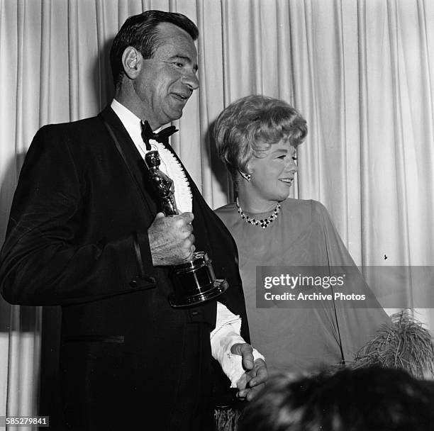 Actor Walter Matthau holding his Best Supporting Actor Oscar for the film 'The Fortune Cookie', with presenter Shelley Winters, at the 39th Academy...