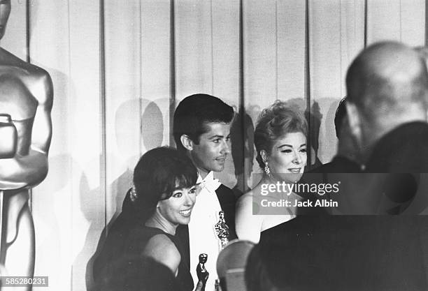 Actors Rita Moreno and George Chakiris holding the acting Oscars they won for the film 'West Side Story', with actress Greer Garson at the 39th...