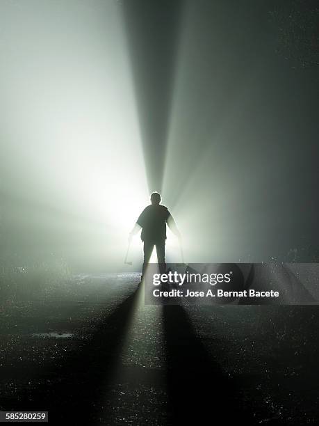 road with a silhouette of a man with an ax - stalker person stock pictures, royalty-free photos & images