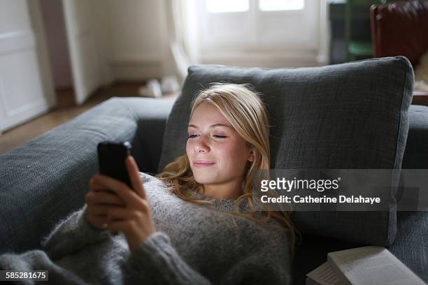 a 18 years old young woman with a smartphone - sofa stock-fotos und bilder