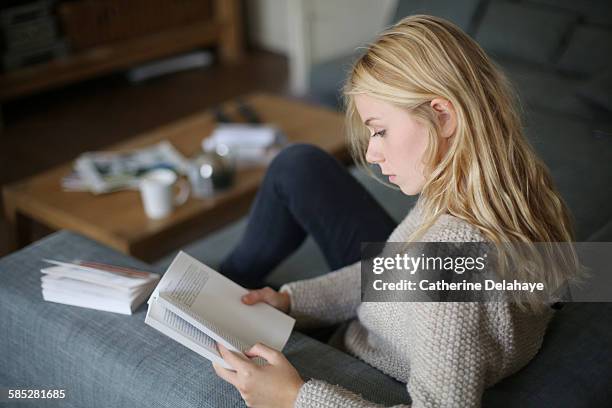 a 18 years old young woman reading a book - 16 17 girl blond hair stock pictures, royalty-free photos & images