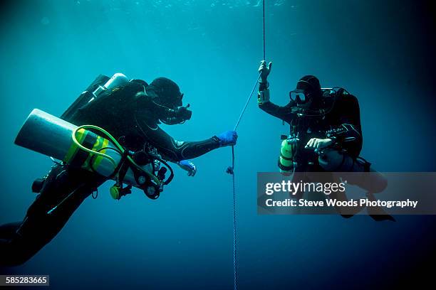 underwater view of two technical divers using rebreathers device to locate shipwreck, lombok, indonesia - dykarutrustning bildbanksfoton och bilder