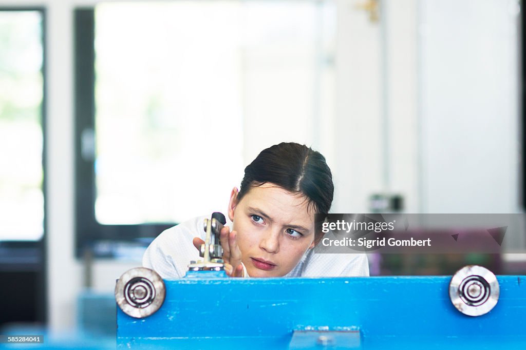 Head and shoulders of young woman operating machine