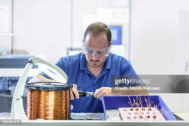male worker assembling electromagnetic coils in electronics factory - highlight reel stock pictures, royalty-free photos & images