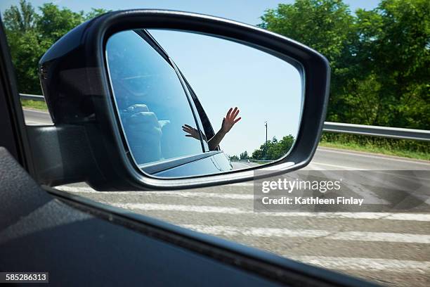 close up of mother photographing sons hand reflected in wing mirror - vehicle mirror stock pictures, royalty-free photos & images