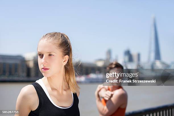 runners stretching on riverfront, wapping, london - coupeville stock pictures, royalty-free photos & images