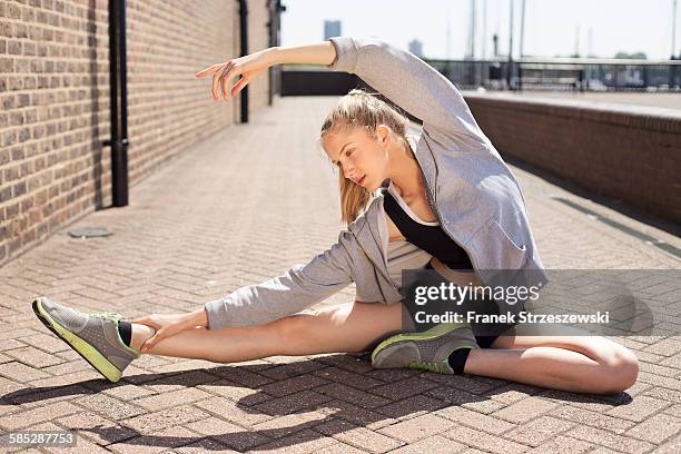 runner stretching on walkway, wapping, london - coupeville stock pictures, royalty-free photos & images