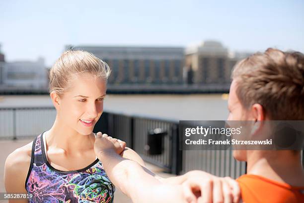 runners stretching on riverfront, wapping, london - coupeville stock pictures, royalty-free photos & images