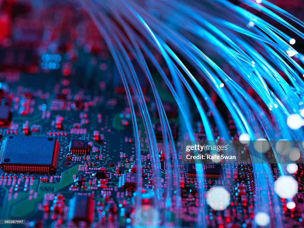 Fibre optics flowing through circuit boards from a laptop computer, close-up