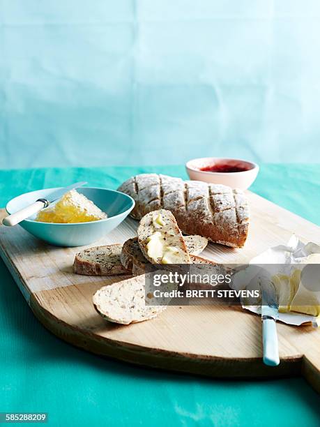 cutting board with fresh unkneaded bread with honey, butter and jam - vollkornbrot stock-fotos und bilder