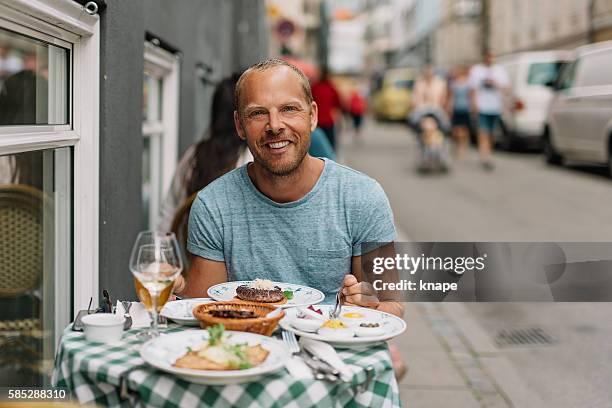 man sitting on a walkway cafe on summer day - 開放式三文治 個照片及圖片檔