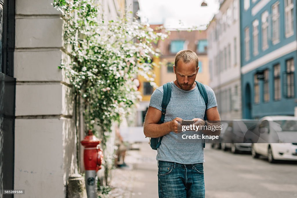 Man playing mobile game on his phone looking down