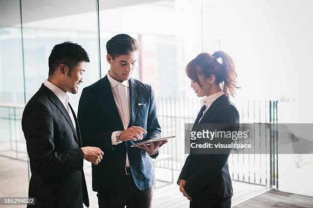 riunione di lavoro in office - man suit using phone tablet foto e immagini stock