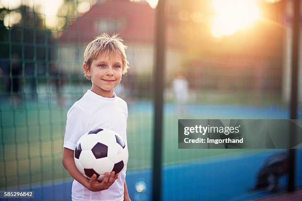 little boy playing football in the schoolyard - boy playing soccer stock pictures, royalty-free photos & images