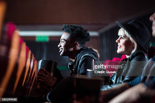 multi ethnic young people in the movie theater - cinema audience imagens e fotografias de stock