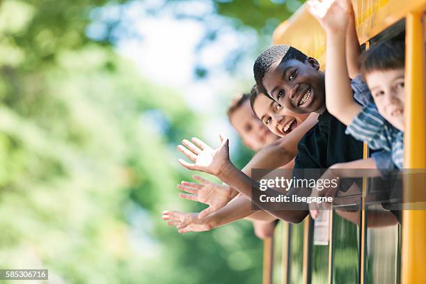 school kids hanging out bus windows - school bus kids stock pictures, royalty-free photos & images