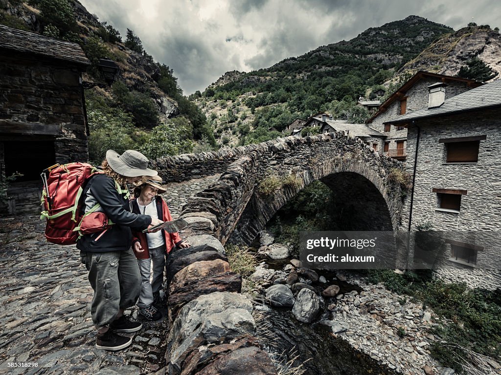 Woman and child looking map before stating mountain hike