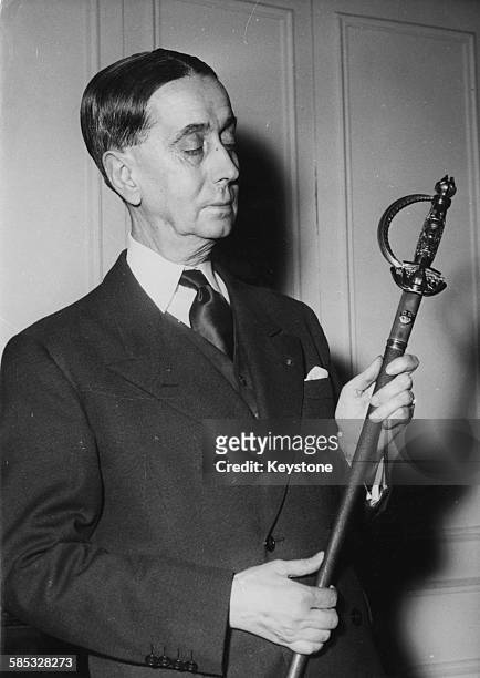 French writer and historian Daniel Rops holding his Academician's Sword, presented to him at the French Academy, February 22nd 1956.