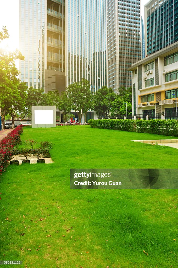 Empty green field around by business zone in Guangzhou,China.