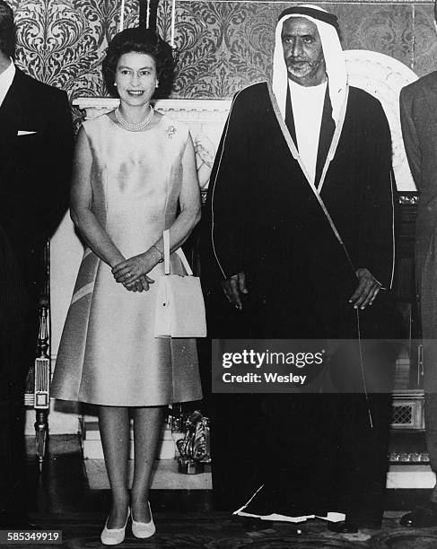Queen Elizabeth II and Sheikh Rashid Saeed Al Maktoum, Ruler of Dubai, attending a luncheon at Buckingham Palace, London, July 22nd 1969.