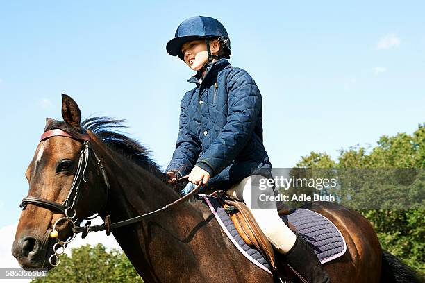 girl riding horse in countryside - riding helmet stock pictures, royalty-free photos & images