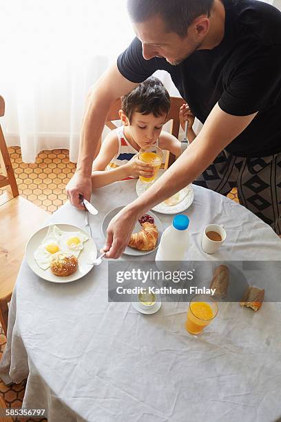 father and son having breakfast - milk bottle photos et images de collection