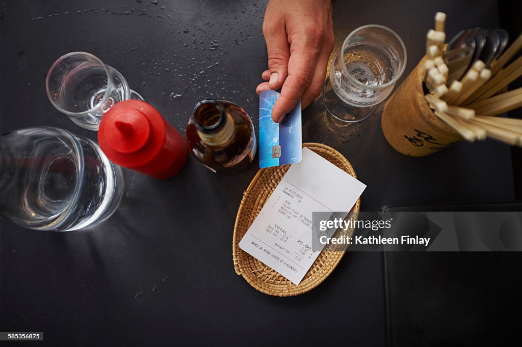 Overhead view of man paying with credit card