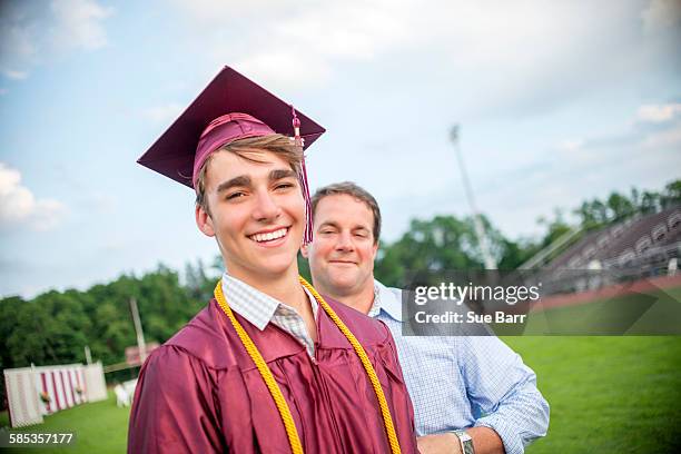 young man standing with father at graduation ceremony - son graduation stock pictures, royalty-free photos & images