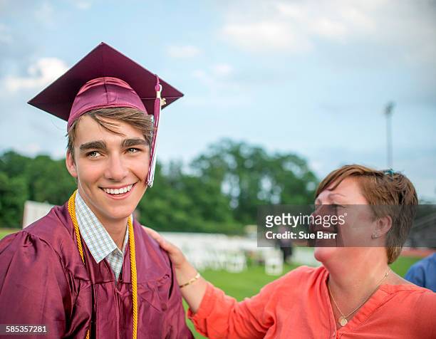 young man standing with mother at graduation ceremony - son graduation stock pictures, royalty-free photos & images