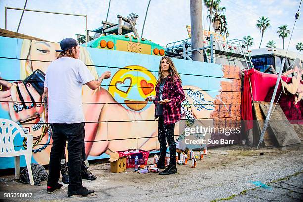 Graffiti artists by painted wall, Venice Beach, California, USA