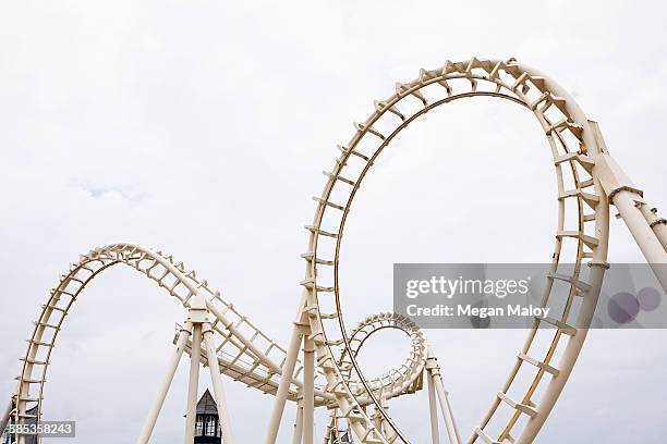 view of amusement park rollercoaster against grey sky - montaña rusa fotografías e imágenes de stock