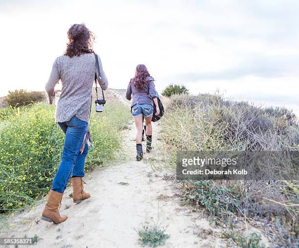 rear view of two adult sisters walking along dirt track - woodland hills los angeles imagens e fotografias de stock