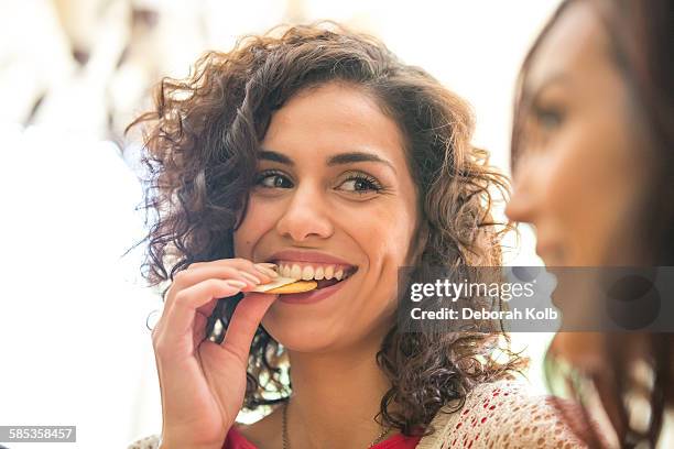 young woman and sister snacking on cheese and biscuits - snacks stock-fotos und bilder