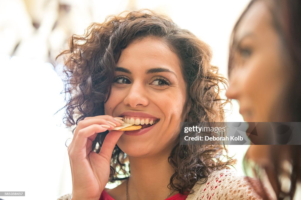 Young woman and sister snacking on cheese and biscuits