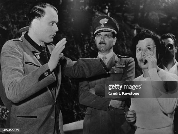 German Nazi officer Walter Reder talking to a woman during an on the spot investigation during World War Two in Marzabotto, circa 1944. Printed...