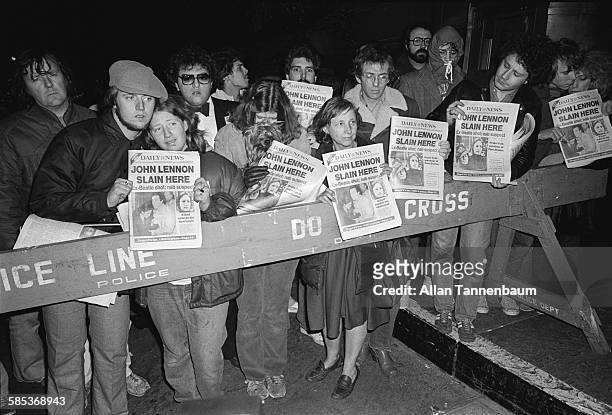 View of fans behind a police barrier outside the Dakota Apartments during a memorial vigil for murdered musician John Lennon, New York, New York,...